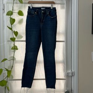 Good American medium wash raw hem jeans